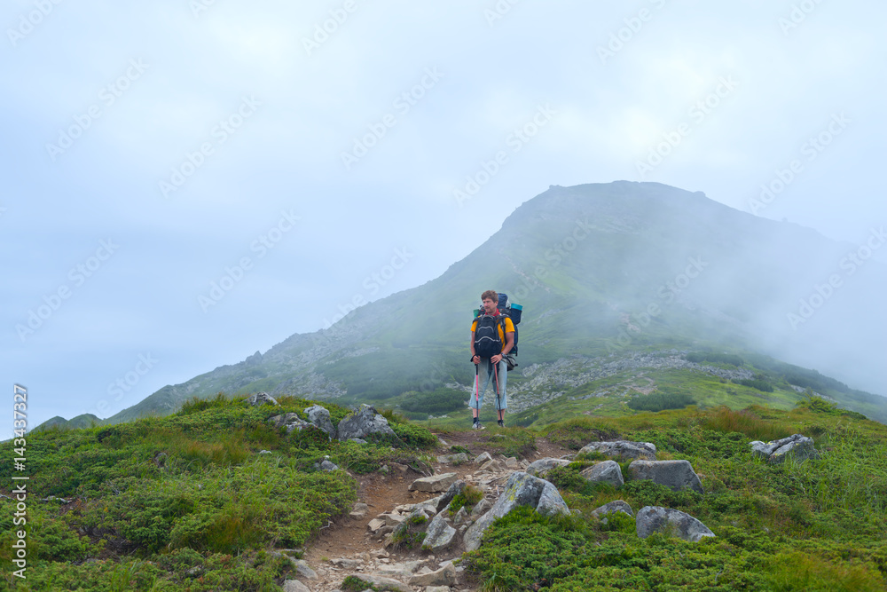 Man, traveler with big backpack goes the mountain trail Man, traveler with big backpack goes the mountain trail