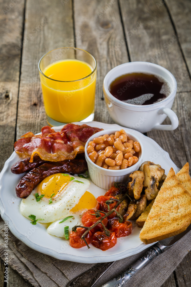 Full english breakfast - eggs, bacon, beans, toast, coffee and juice