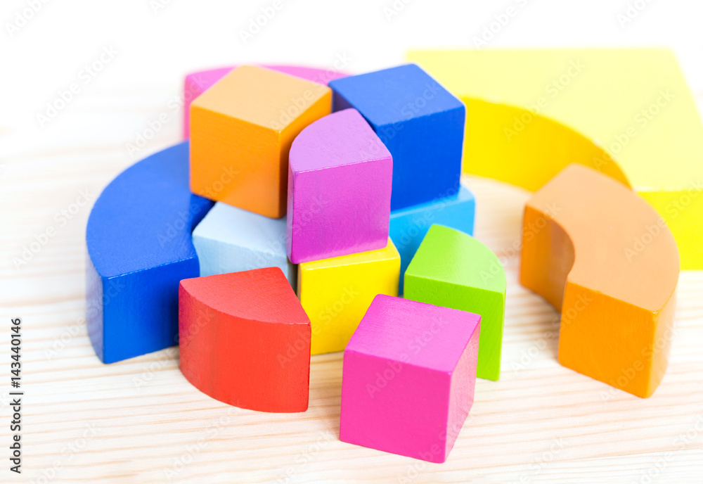 Colored wooden blocks, cubes, build on a light wooden background. Colored wooden blocks, cubes, build on a light wooden background.
