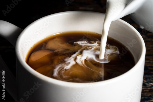 Pouring Cream into a Cup of Coffee