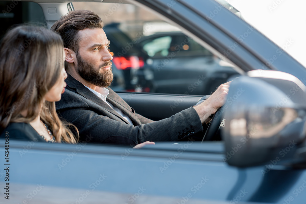 Beautiful business couple driving a car in the city Beautiful business couple driving a car in the city