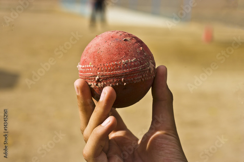 Caucasian boy holiding old cricket ball. photo