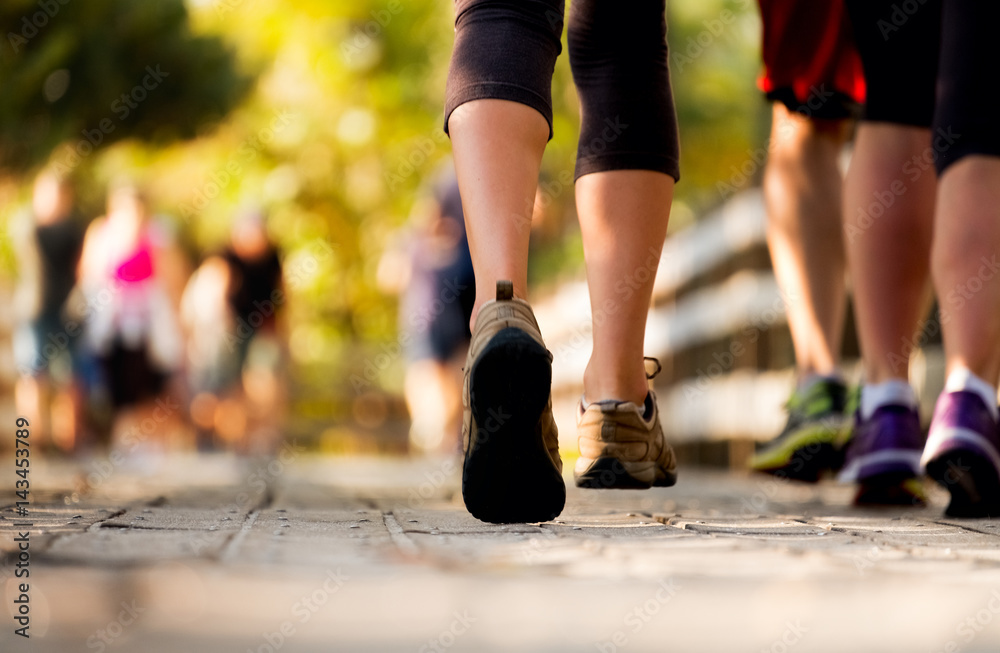 Fototapeta premium Close up of the legs of woman running on the wooden walkway in the park