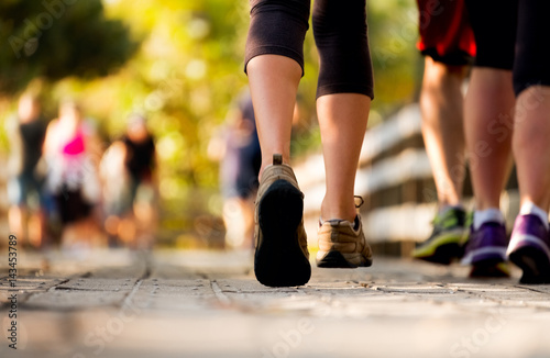 Close up of the legs of woman running on the wooden walkway in the park