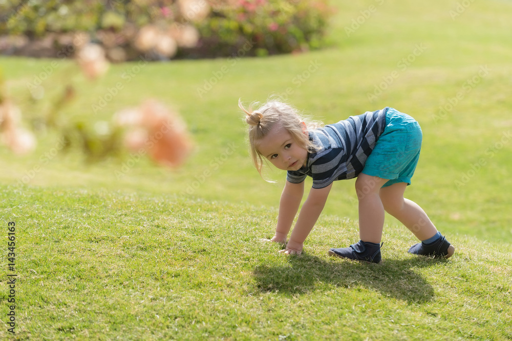 Cute baby boy playing on green grass Cute baby boy playing on green grass