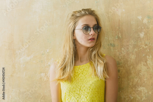 Pretty girl with long blonde hair in yellow dress  sunglasses