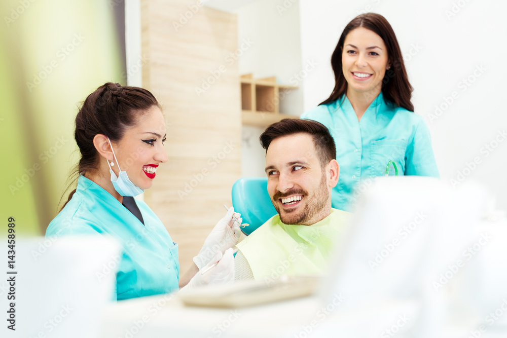 Fototapeta premium A dentist with assistant working on a patient