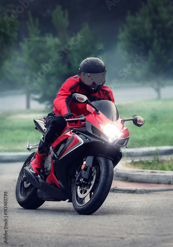 Canvas Print Biker in helmet ride on the red motorcycle