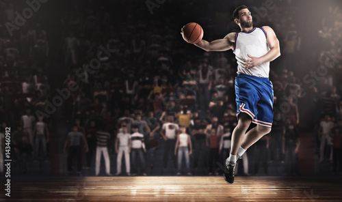 basketball player jumping with ball on stadium in lights © masisyan