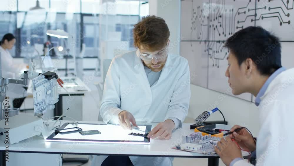 Electronics engineers working in lab building & testing electronic devices Electronics engineers working in lab building & testing electronic devices