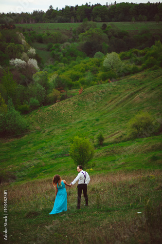 The lovely couple in love walking along mountains