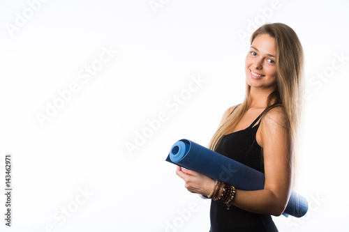 exercise fitness woman ready for workout standing holding yoga mat isolated on white background. Sporty fit beautiful blonde girl. Caucasian female fitness model.
