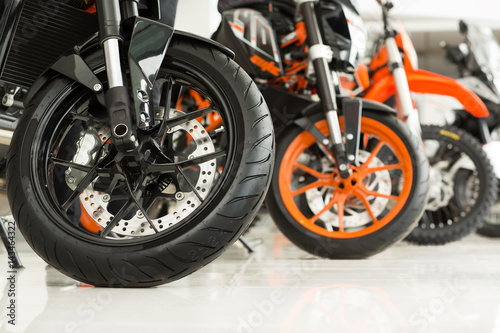 Riders will love. Cropped shot of the wheels of motorbikes standing in the line at the motorcycle salon