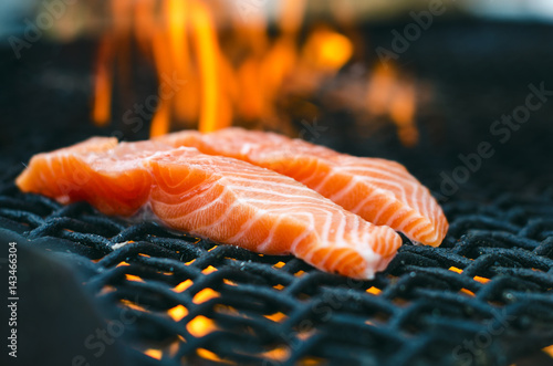 Grilled salmon steaks on a grill. Fire flame grill. Restaurant and garden kitchen. Garden party. Healthy dish.