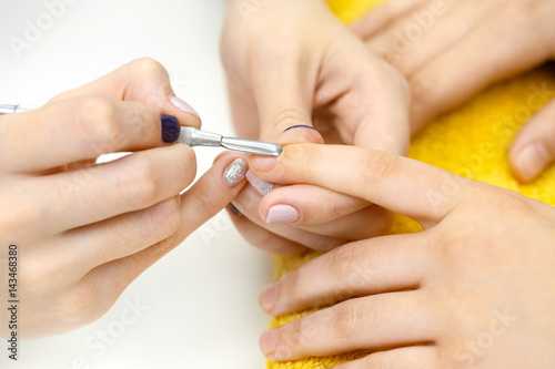 Preparing nails. Closeup shot of a manicurist pushing client cuticle back