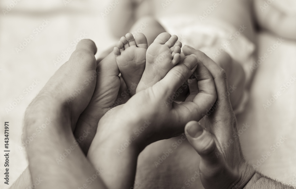 Mother holding tiny foot of newborn baby Mother holding tiny foot of newborn baby