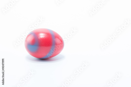 Easter egg hand painted in home - red with blue grey stripes, isolated in white background