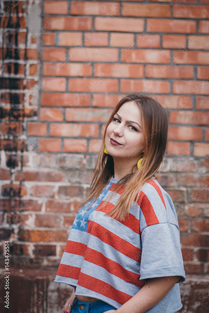 A hipster girl in an old courtyard posing and smiling A hipster girl in an old courtyard posing and smiling