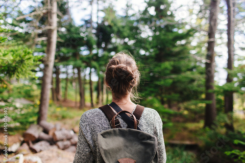 Young woman with backpack in forest