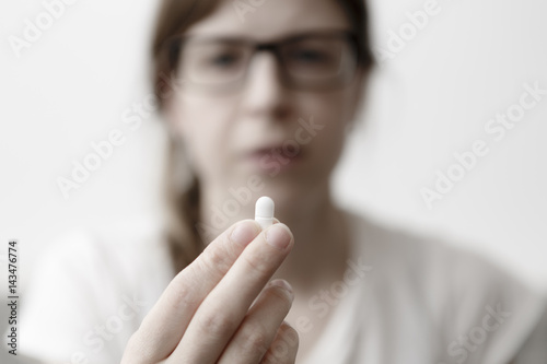 yound woman is eating pills or vitamin