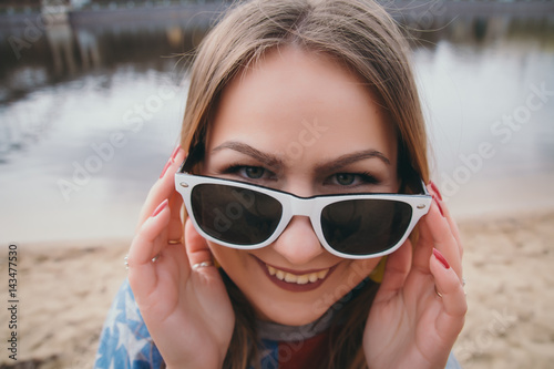 A girl hippy on the river bank posing and smiling