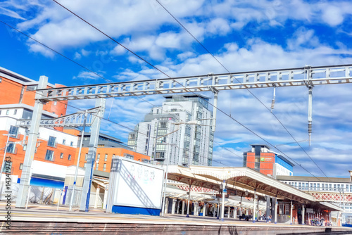 Urban mainline station with overhead live electric wires on a bright sunny day photo
