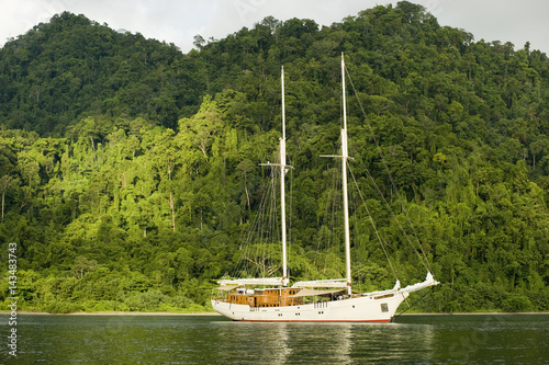 Scenic view of Batanta Island and a sailing boat, Raja Ampat Indonesia. photo