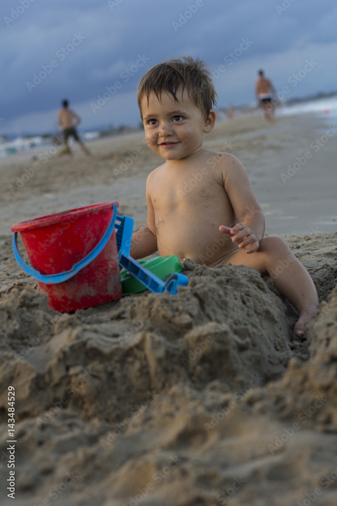 Baby smiling while playing on the beach Baby smiling while playing on the beach