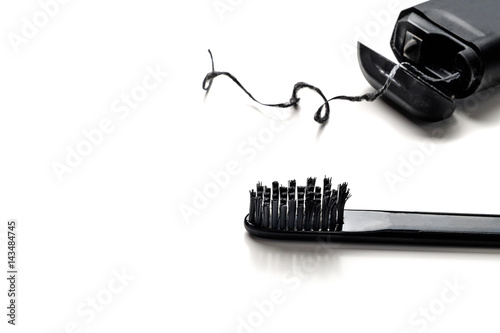 black toothbrush and dental floss isolate on white background