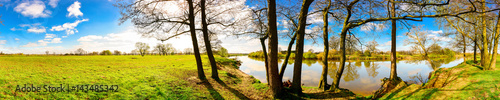 Panorama einer Landschaft im Frühling mit blauen Himmel, Sonne, Wiese und Fluss © Günter Albers
