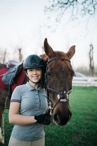 Beautiful young teenage girl enjoying with her horse. Selective focus on horse's eye.