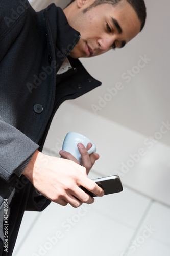 Man with cup of coffee and mobile phone
