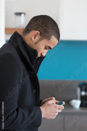 Man in black coat looking at cell phone