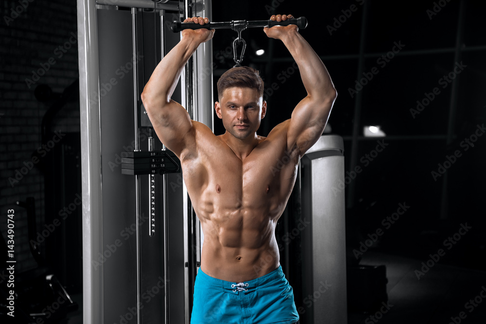 Young handsome guy doing exercises in the gym Young handsome guy doing exercises in the gym