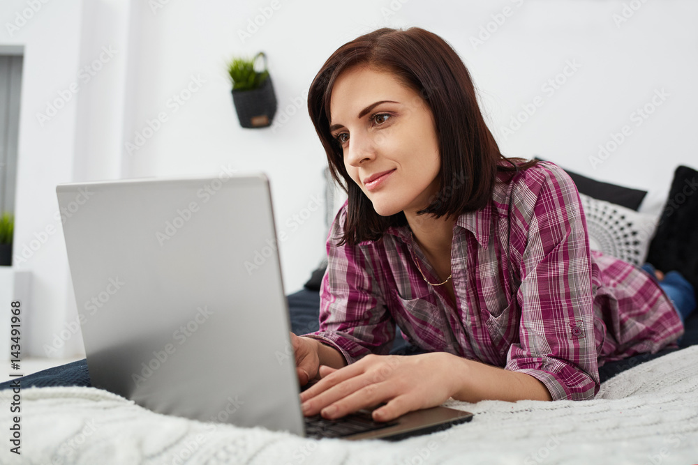 Young freelancer woman using laptop.Happy smiling girl working on line.Work at home.Studying and learning using notebook computer.Enjoy working.Freelance work,business people concept.Home office Young freelancer woman using laptop.Happy smiling girl working on line.Work at home.Studying and learning using notebook computer.Enjoy working.Freelance work,business people concept.Home office