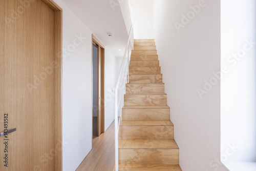 white passage with wood stair  door.