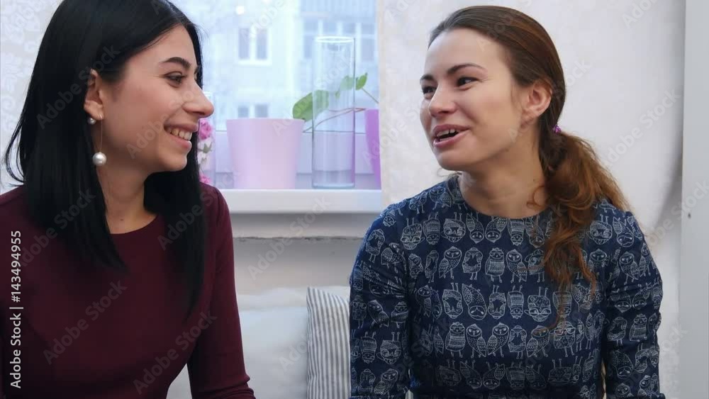 Smiling young women drinking coffee or tea and gossiping Smiling young women drinking coffee or tea and gossiping