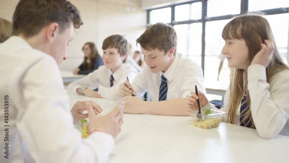 Children in school cafeteria at break time, eating healthy lunches & chatting Children in school cafeteria at break time, eating healthy lunches & chatting