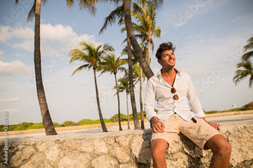 Guy sitting under the palms while sunset