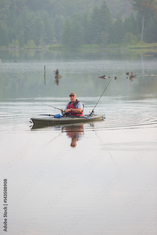 Middle aged man kayak fishing