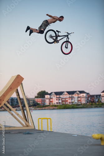 Obraz na płótnie Man jumps a bicycle into the water from a pier w salonie