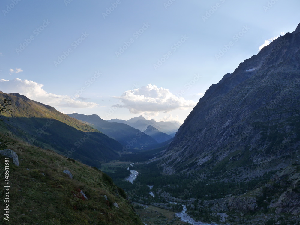 Sunset mountain valley with small river and steep mountains Sunset mountain valley with small river and steep mountains