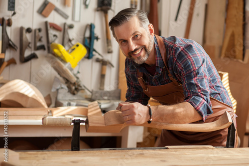 Working With Wood Gives Joy/Carpenter works with a planer in a workshop for the production of vintage furniture. He makes cabriole leg for a table in the style of Louis XV