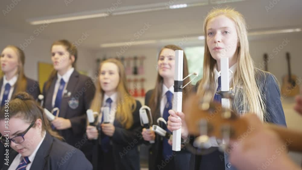 Group of teen girls playing percussion instruments in school music lesson Group of teen girls playing percussion instruments in school music lesson