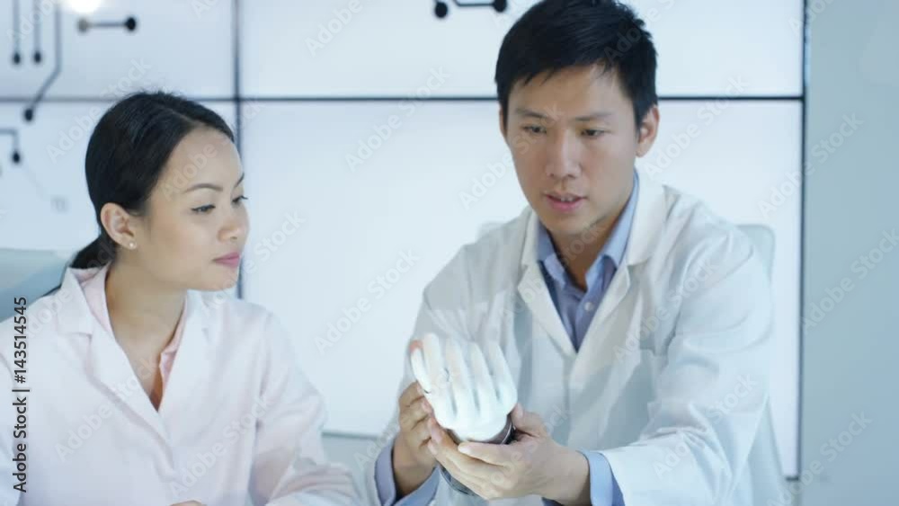  Scientific research engineers collaborating on project to build robotic hand