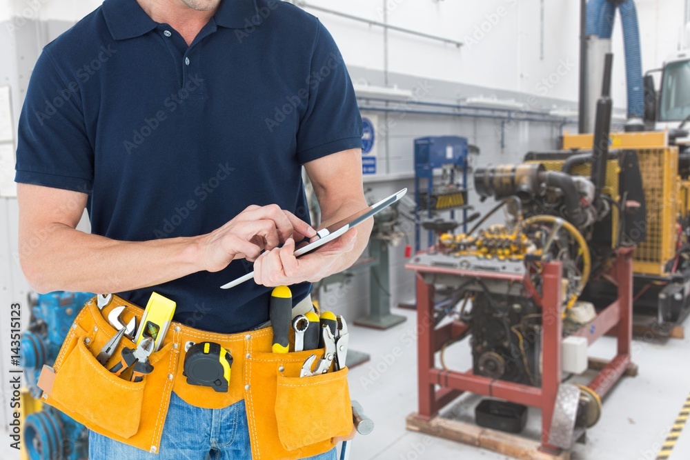 Midsection of handyman using tablet PC at workshop Midsection of handyman using tablet PC at workshop