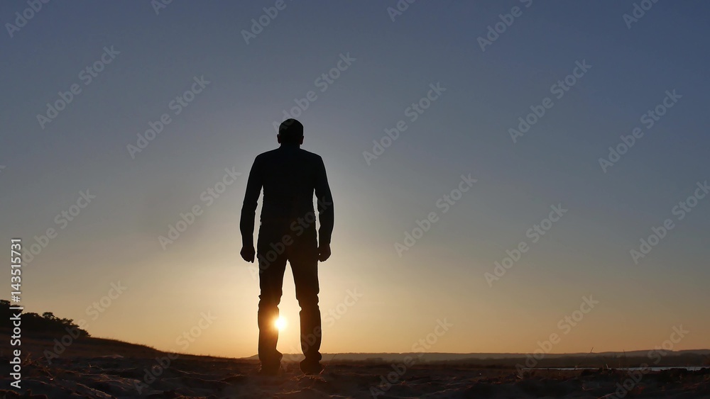 freedom. Man stands on a cliff sunset silhouette hand in lifestyle the sides