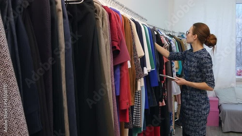 Female business owner using tablet computer in clothes shop photo