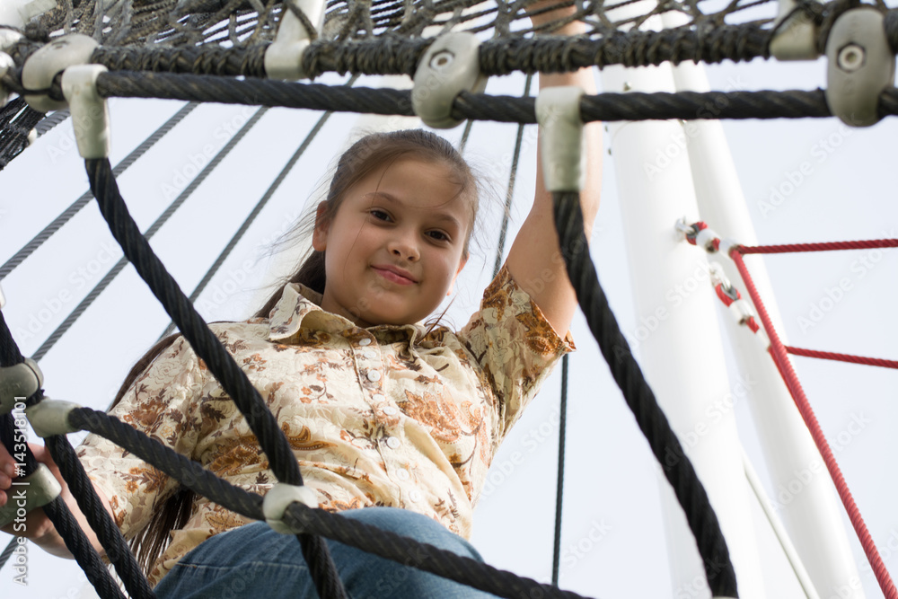 Girl playing in the park. Little girl climbing on outdoor playground Girl playing in the park. Little girl climbing on outdoor playground