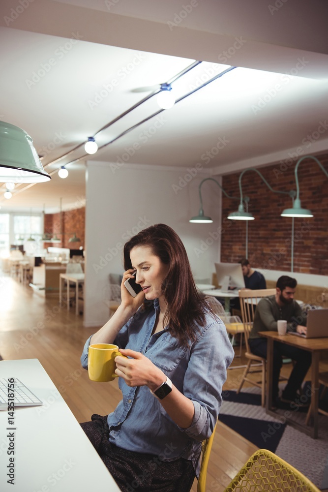 Female executive talking on mobile phone Female executive talking on mobile phone